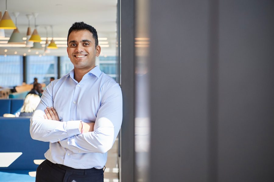 Man leant against the wall smiling at the camera