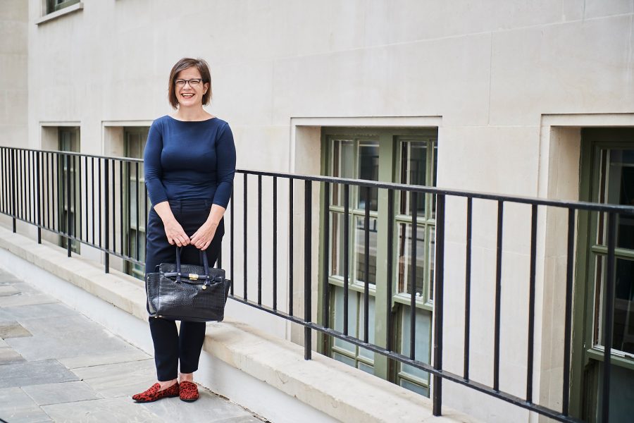 Woman stood in front of railings smiling at camera