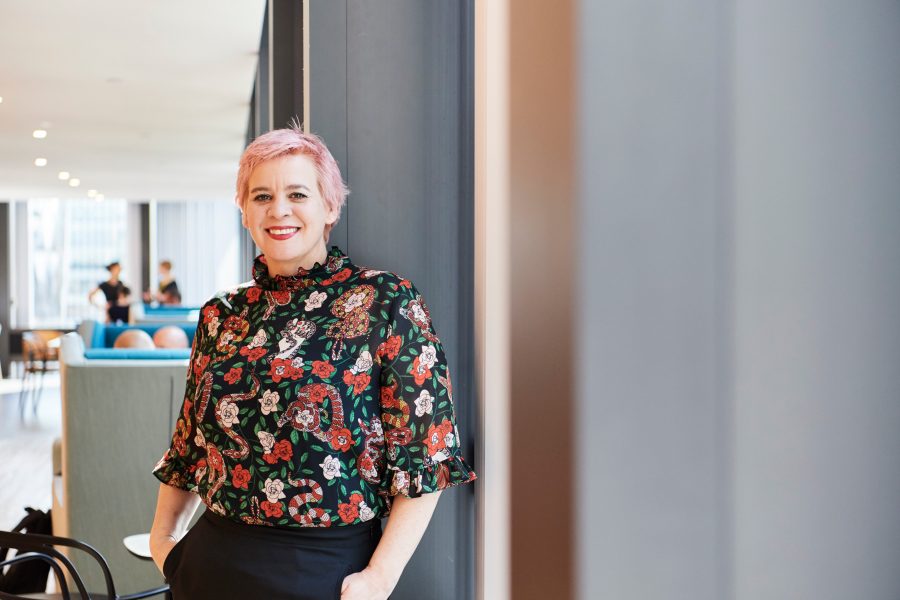Short-haired woman in a floral top, smiling at the camera