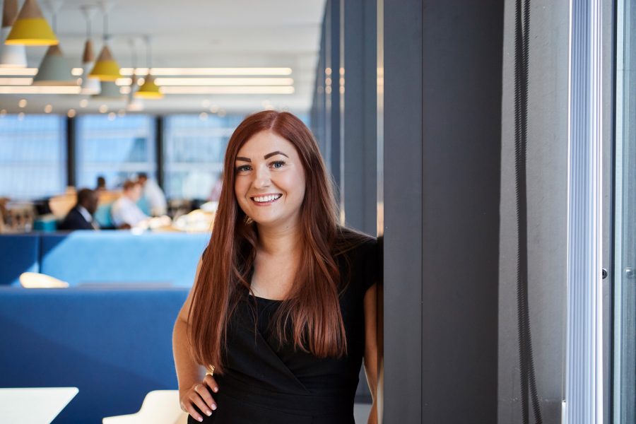 Long-hair woman in an office smiling at the camera