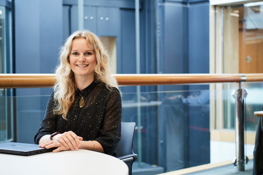 Woman sat at table smiling at the camera